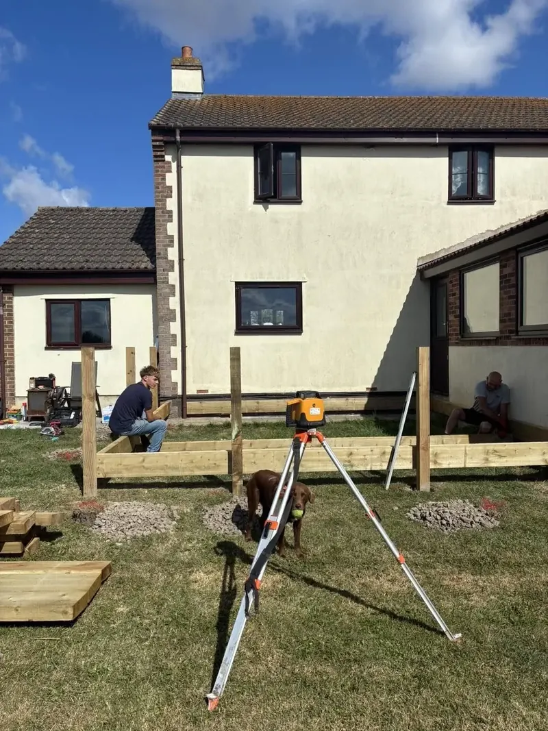 The deck frame being checked with a laser level on a tripod