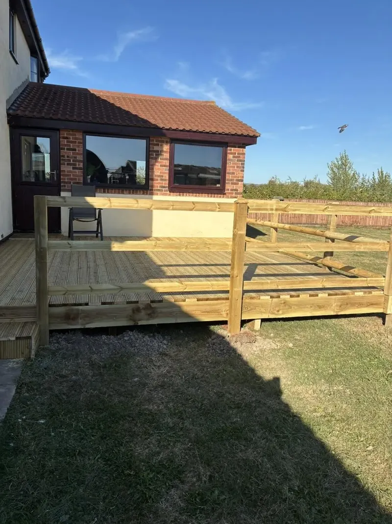 Deck boards going down over the frame, posts standing at the edge