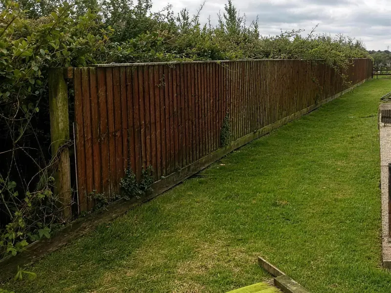 An old weathered fence along a garden path, before it was replaced