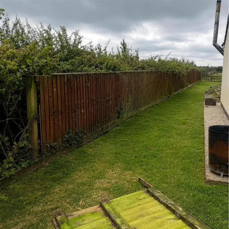 Before: the old fence along a garden path, weathered and leaning