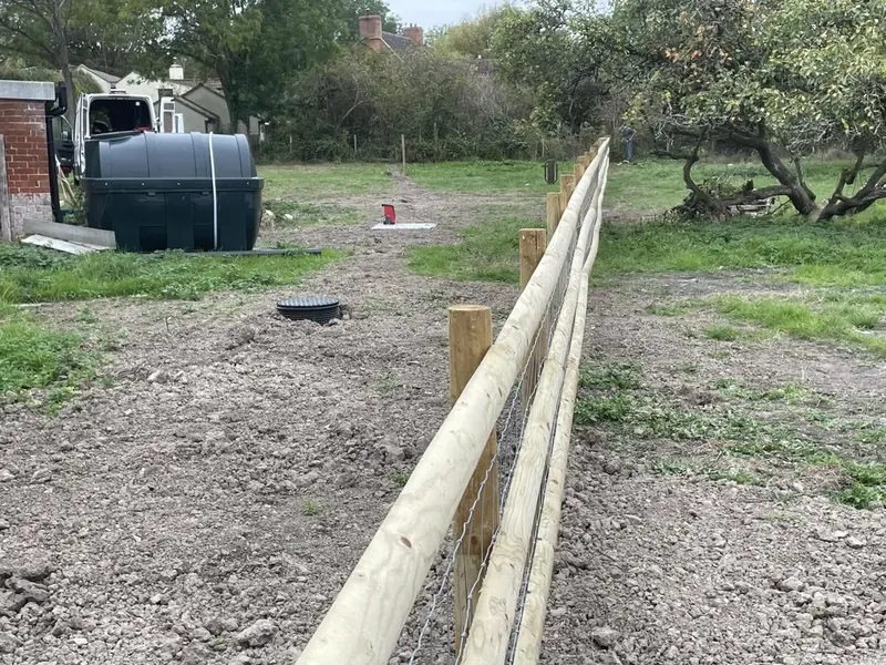 The post and rail line running away across a cleared paddock